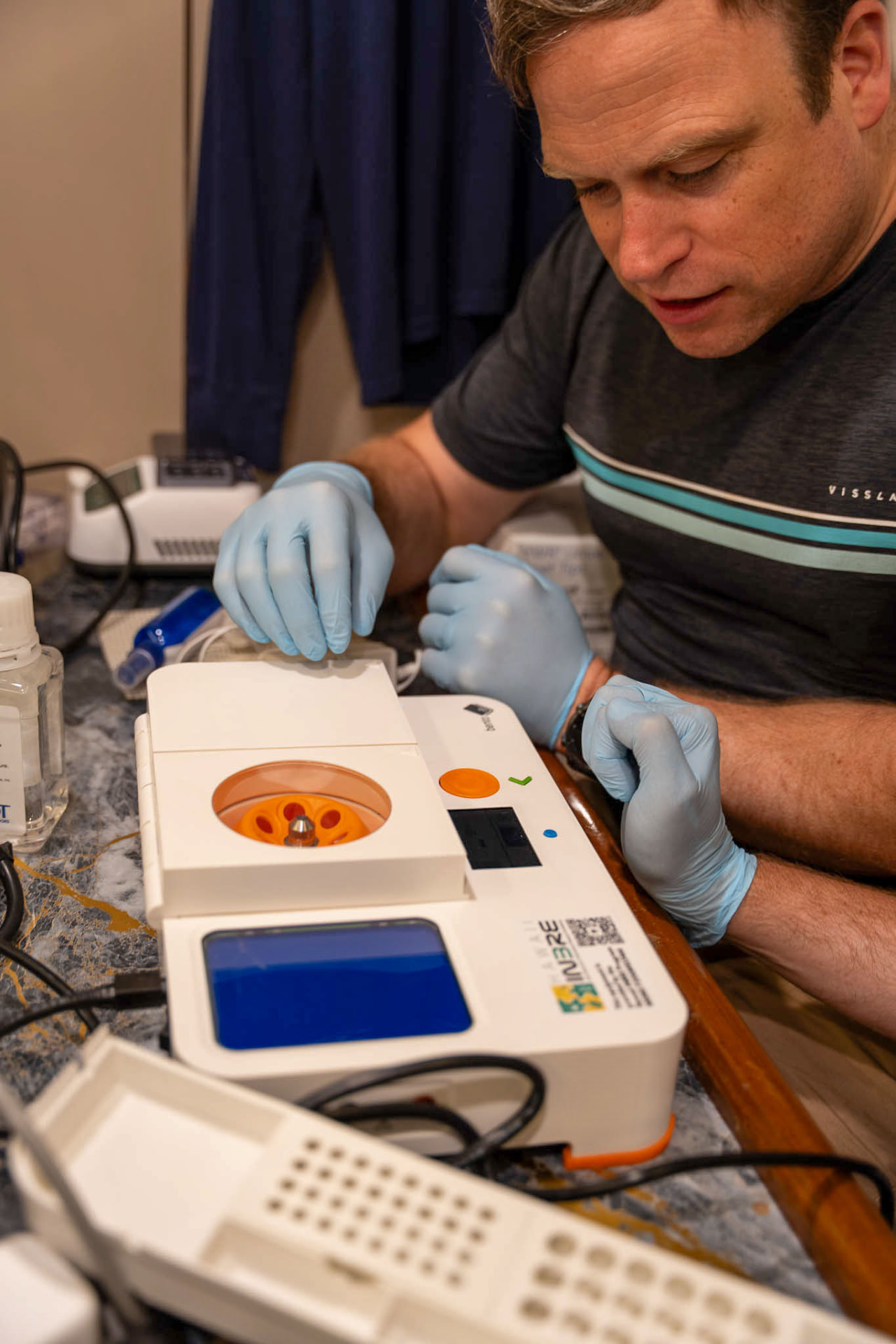 A scientist loading samples into a centrifuge in the onboard DNA sequencing lab
