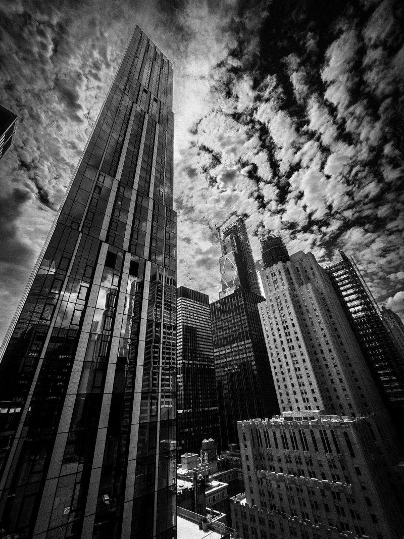 Black and white view looking up at Manhattan skyscrapers from below