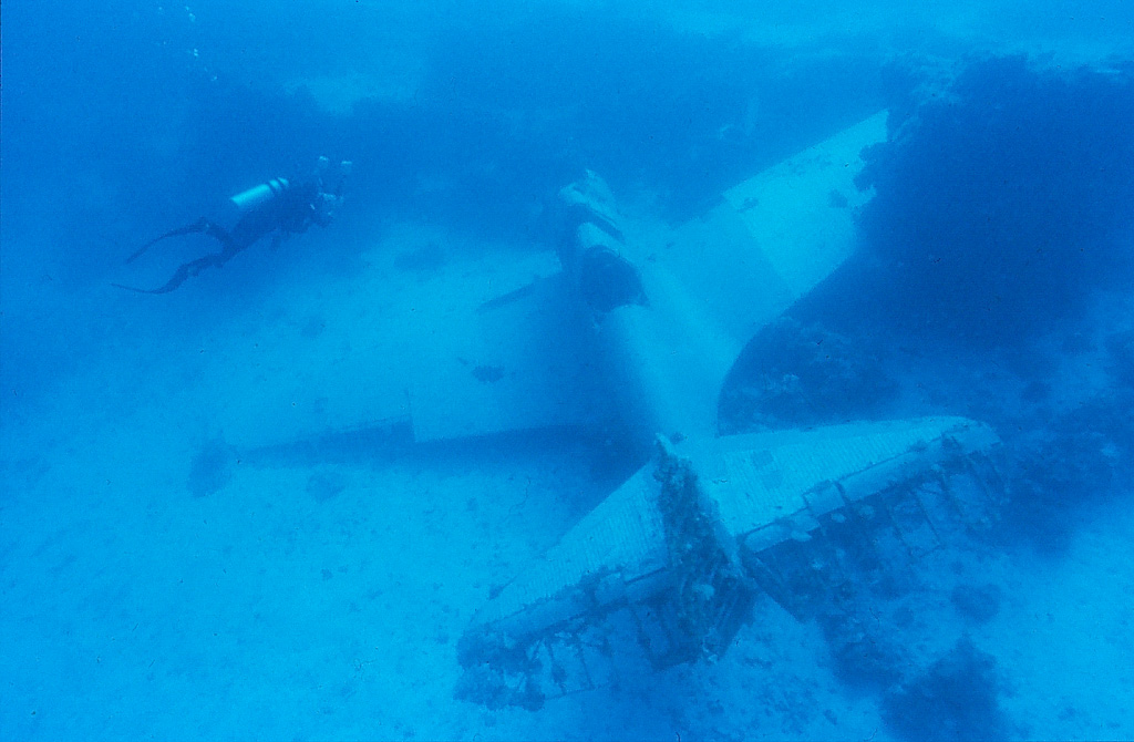A diver swims over the wreck of a Douglas Devastator lying in the sand of Jaluit Lagoon