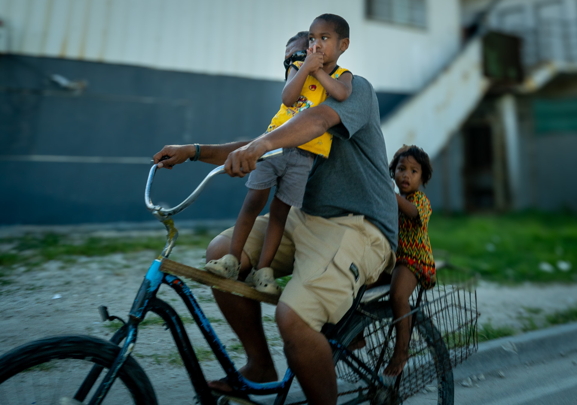 A man cycling with two children on his bicycle on Ebeye, Marshall Islands