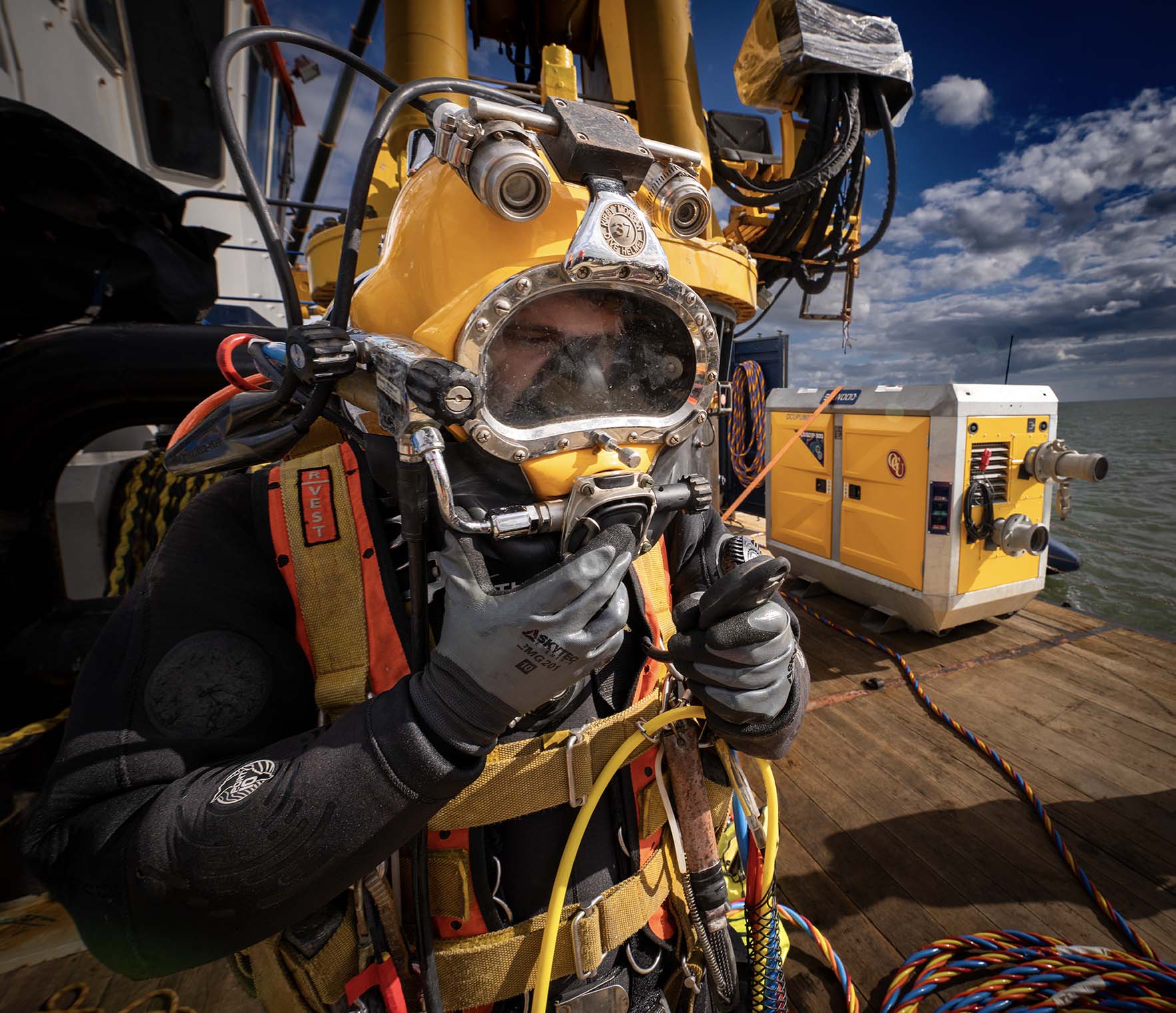 Close portrait of a commercial diver wearing a yellow surface-supplied diving helmet