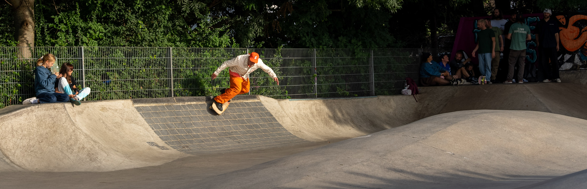 Mark Gonzales riding over the brick ledge of the skatepark bowl in golden light