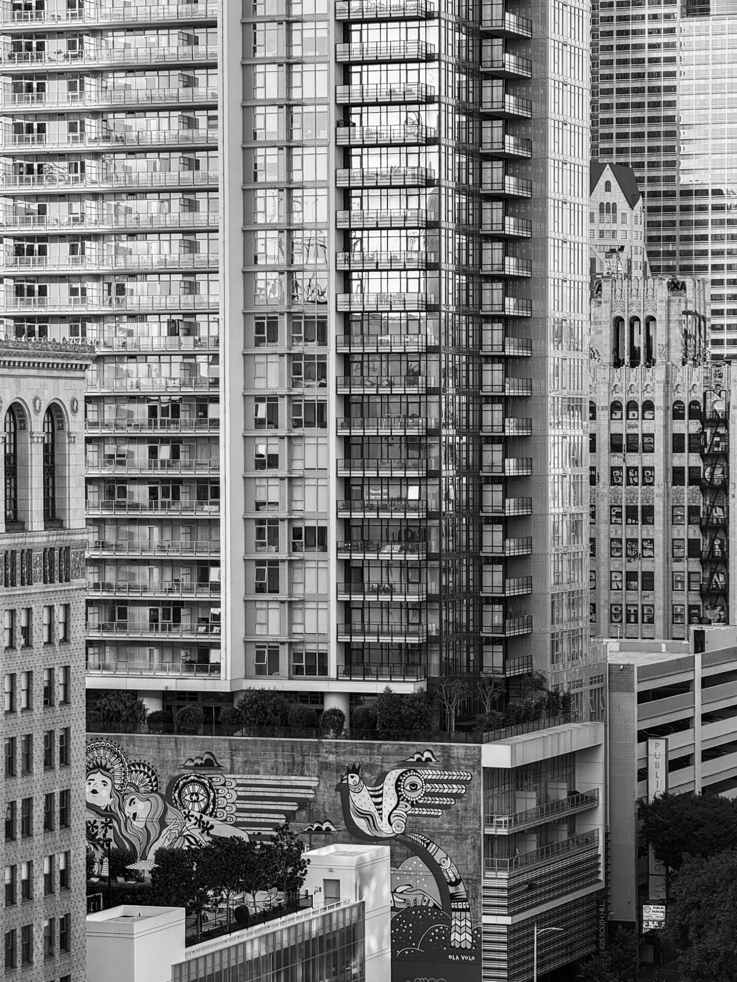 Black and white photograph of downtown Los Angeles towers above a painted mural