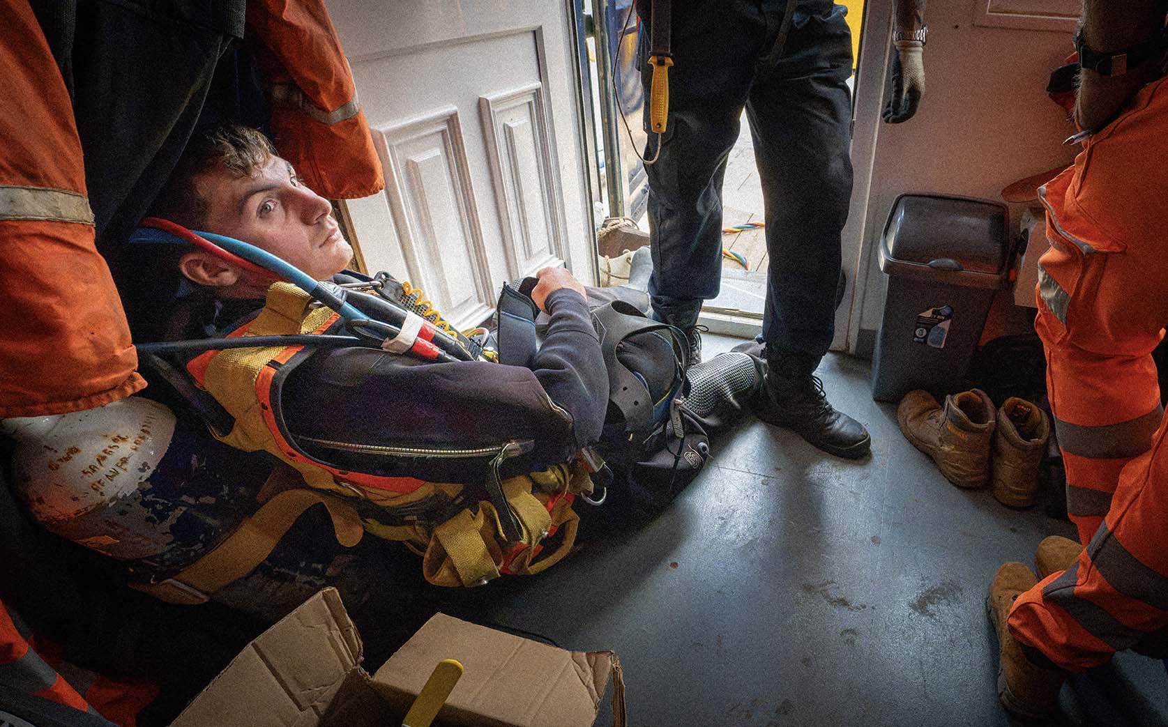 A young diver in full equipment waiting on the cabin floor among the crew's boots