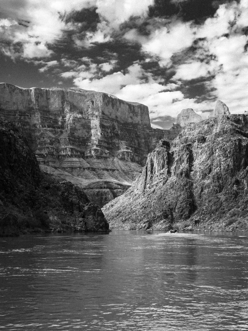 A raft on the Colorado River beneath the canyon walls of the Grand Canyon